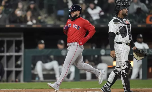 Boston Red Sox's Wilyer Abreu, left, scores on a sacrifice fly by Blake Sabol during the seventh inning of a baseball game against the Chicago White Sox, Friday, April 11, 2025, in Chicago. (AP Photo/Erin Hooley)