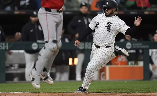 Chicago White Sox's Omar Narváez, right, slides into home to score on a double by Miguel Vargas during the fourth inning of a baseball game against the Boston Red Sox, Friday, April 11, 2025, in Chicago. (AP Photo/Erin Hooley)