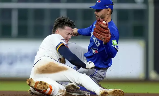 Houston Astros' Zach Dezenzo, left, collides with Toronto Blue Jays second baseman Andres Gimenez, right, while sliding into second for a double during the seventh inning of a baseball game Monday, April 21, 2025, in Houston. (AP Photo/Eric Christian Smith)