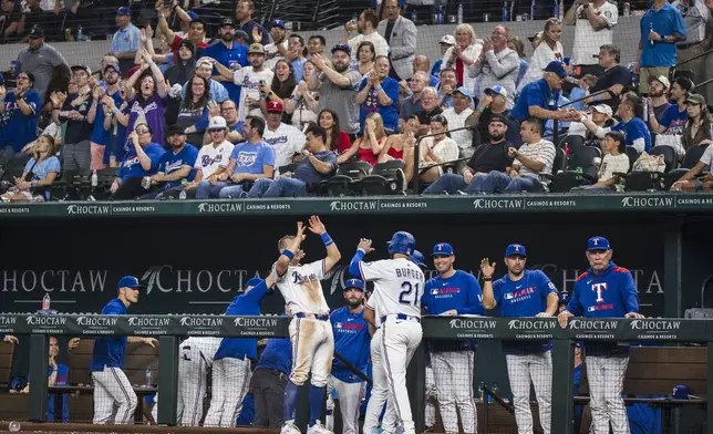 Texas Rangers' Josh Jung celebrates with Texas Rangers' Jake Burger (21) in front of the dugout after runs scored in the sixth inning of a baseball game against the Athletics, Tuesday, April 29, 2025, in Arlington, Texas. (AP Photo/Jessica Tobias)