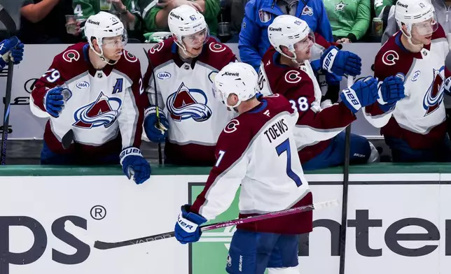 Colorado Avalanche defenseman Devon Toews (7) celebrates with teammates after scoring during a first-round NHL hockey playoff game against the Dallas Stars in Dallas, Saturday, April 19, 2025. (AP Photo/Gareth Patterson)
