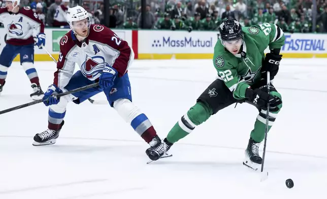 Dallas Stars center Mavrik Bourque (22) controls the puck as Colorado Avalanche center Nathan MacKinnon (29) looks on during a first-round NHL hockey playoff game in Dallas, Saturday, April 19, 2025. (AP Photo/Gareth Patterson)