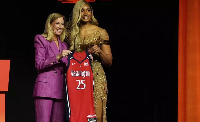 Southern California's Kiki Iriafen, right, poses with WNBA commissioner Cathy Engelbert after being selected fourth overall by the Washington Mystics during the first round of the WNBA basketball draft, Monday, April 14, 2025, in New York. (AP Photo/Pamela Smith)