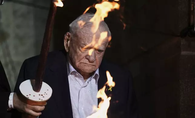 Holocaust survivor Arie Durst lights a torch during the opening ceremony of the Holocaust Remembrance Day at the Yad Vashem Holocaust Memorial Museum in Jerusalem on Wednesday, April 23, 2025. (AP Photo/Leo Correa)