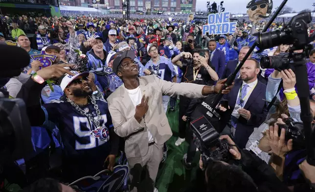 Miami quarterback Cam Ward takes a selfie with fans after being chosen by the Tennessee Titans with the first overall pick during the first round of the NFL football draft, Thursday, April 24, 2025, in Green Bay, Wis. (AP Photo/Matt Ludtke)