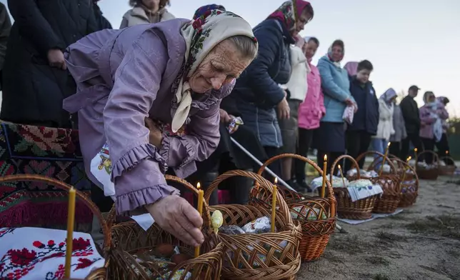 An elderly woman prepares her Easter baskets to be blessed during celebration of the Orthodox Easter in Krasne village, Ukraine, on Sunday, April 20, 2025. (AP Photo/Evgeniy Maloletka)