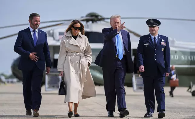 President Donald Trump, escorted by Col. Paul Pawluk, Vice Commander of the 89th Airlift Wing, and first lady Melania Trump, walk to board Air Force One for a trip to attend the funeral of Pope Francis, Friday, April 25, 2025, at Andrews Air Force Base, Md. Derek Rea is left. (AP Photo/Evan Vucci)