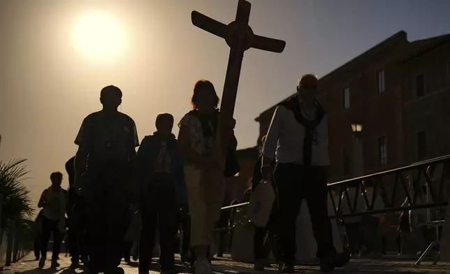 Pilgrims arrive in St. Peter's Square at the Vatican, Tuesday, April 22, 2025. (AP Photo/Francisco Seco)