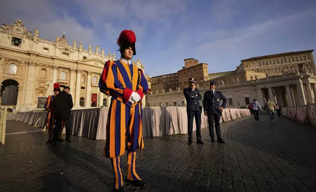 Pontifical Swiss guards stand in St. Peter's Square before the arrival of the body of Pope Francis, who will lie in state at St. Peter's Basilica for three days, at the Vatican, Wednesday, April 23, 2025. (AP Photo/Andreea Alexandru)