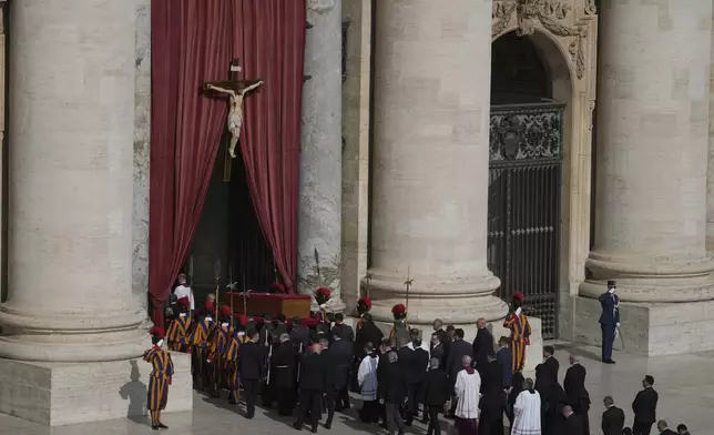The body of Pope Francis is carried through St. Peter's Square to St. Peter's Basilica at the Vatican, Wednesday, April 23, 2025, where he will lie in state for three days. (AP Photo/Markus Schreiber)