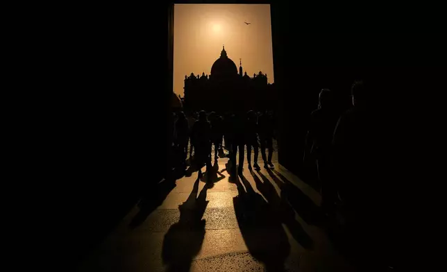 People walk around St. Peter's Square at the Vatican, Tuesday, April 22, 2025. (AP Photo/Andreea Alexandru)