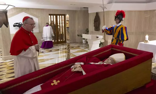 Vatican Secretary of State Cardinal Pietro Parolin, left, prays in front of the body of Pope Francis laid out in state inside his private chapel at the Vatican, Monday, April 21, 2025. (Vatican Media via AP, HO)