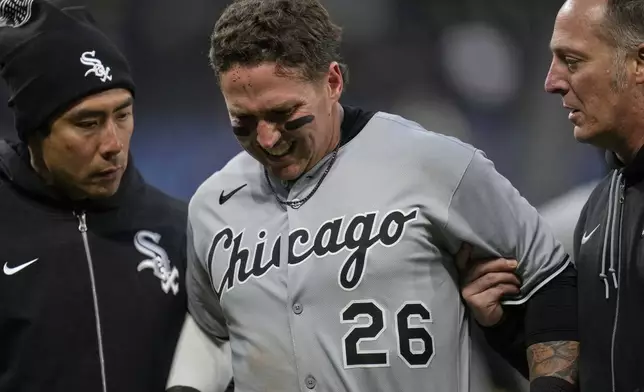 Chicago White Sox's Korey Lee grimaces as he is helped off the field after injuring himself at first base in the sixth inning of a baseball game against the Cleveland Guardians in Cleveland, Wednesday, April 9, 2025. (AP Photo/Sue Ogrocki)