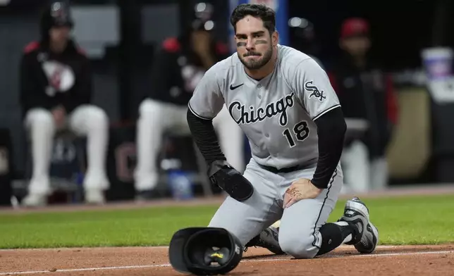 Chicago White Sox's Mike Tauchman (18) kneels after being tagged out by Cleveland Guardians catcher Austin Hedges in the ninth inning of a baseball game in Cleveland, Wednesday, April 9, 2025. (AP Photo/Sue Ogrocki)