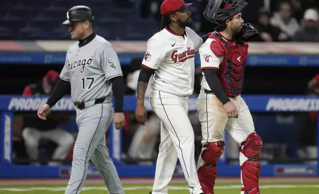 Cleveland Guardians relief pitcher Emmanuel Clase, center and catcher Austin Hedges, right, walk off the field past Chicago White Sox third base coach Justin Jirschele (17) after the Guardians defeated the White Sox in a baseball game in Cleveland, Wednesday, April 9, 2025. (AP Photo/Sue Ogrocki)