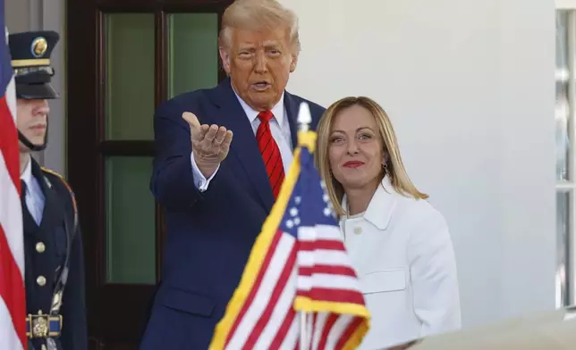 President Donald Trump, center, greets Italy's Prime Minister Giorgia Meloni, right, upon her arrival at the White House, Thursday, April 17, 2025, in Washington. (AP Photo/Tom Brenner)