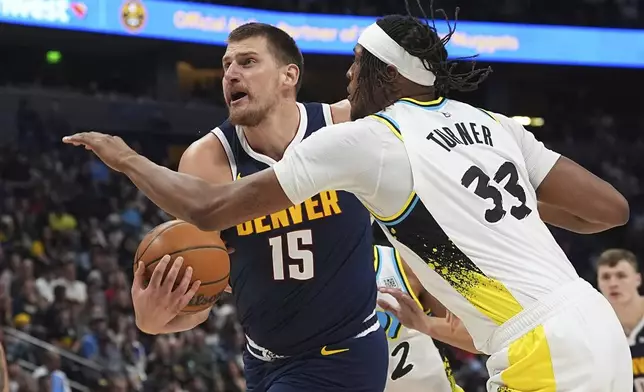Denver Nuggets center Nikola Jokic, left, drives past Indiana Pacers center Myles Turner, right, in the first half of an NBA basketball game Sunday, April 6, 2025, in Denver. (AP Photo/David Zalubowski)