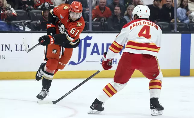 Anaheim Ducks winger Cutter Gauthier, left, attempts to score against Calgary Flames defenseman Rasmus Anderson during the first period of an NHL hockey game, Wednesday, April 9, 2025, in Anaheim, Calif. (AP Photo/Etienne Laurent)