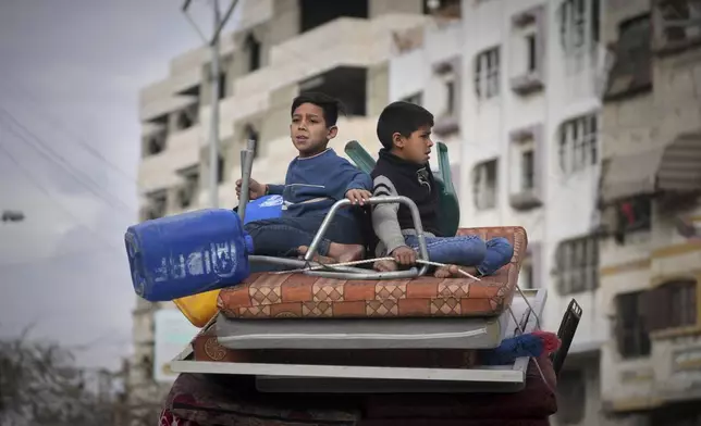 Two boys sit on a mattress as they ride on their family car while s fleeing from east to west of Gaza City after the Israeli military issued evacuation orders in the area, Friday April 11, 2025. (AP Photo/Jehad Alshrafi)