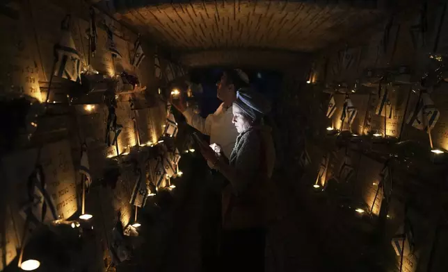People light candles at Mount Herzl military cemetery in Jerusalem on the eve of Israel's annual Memorial Day for the fallen soldiers, Tuesday, April 29, 2025. (AP Photo/Ohad Zwigenberg)