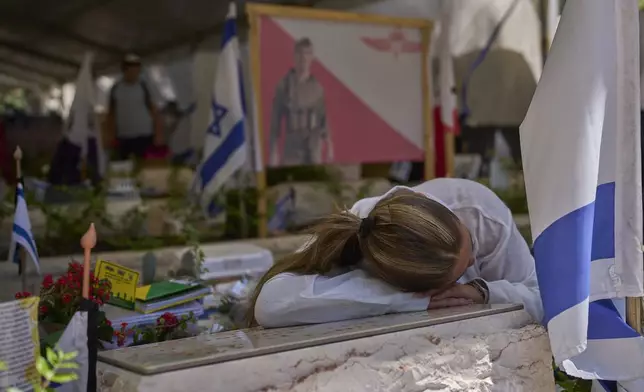 Girlfriend of Liel Haio, an Israeli soldier killed in Gaza, visits his grave on the eve of the Israel's Memorial Day, at the Mount Herzl military cemetery in Jerusalem, Tuesday, April 29, 2025. (AP Photo/Ohad Zwigenberg)
