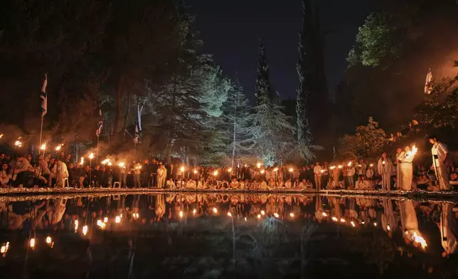 Israeli scouts light torches marking the annual Memorial Day for the fallen soldiers, at Mount Herzl military cemetery in Jerusalem, Tuesday, April 29, 2025. (AP Photo/Ohad Zwigenberg)