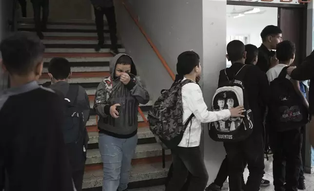 Students react to tear gas fired by Israeli Police into the yard of the UNRWA Boys' School run by the U.N. agency for Palestinian refugees in the Shuafat Refugee Camp in east Jerusalem, Tuesday, April 29, 2025. (AP Photo/Maya Alleruzzo)