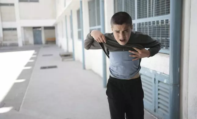 A student reacts to tear gas fired by Israeli Police while he was playing soccer with classmates in the yard of the UNRWA Boys' School, run by the U.N. agency for Palestinian refugees in the Shuafat Refugee Camp in east Jerusalem, Tuesday, April 29, 2025. (AP Photo/Maya Alleruzzo)
