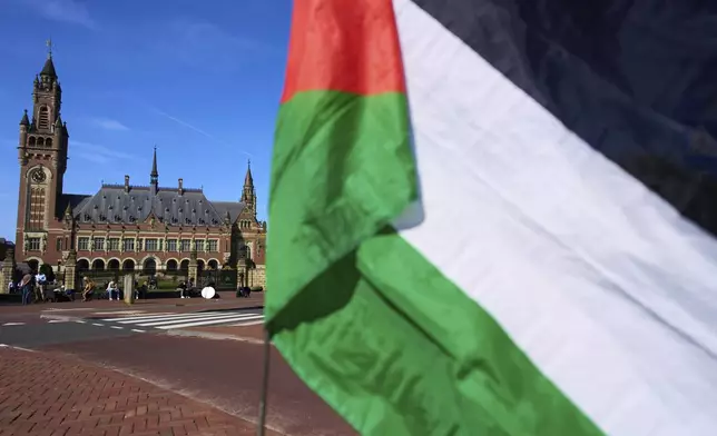 A Palestinian flag flies outside the International Court of Justice, rear, which opened hearings into a United Nations request for an advisory opinion on Israel's obligations to allow humanitarian assistance in Gaza and the West Bank, in The Hague, Netherlands, Monday, April 28, 2025. (AP Photo/Peter Dejong)