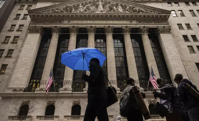 People walk past the New York Stock Exchange, Monday, April 7, 2025, in New York. (AP Photo/Yuki Iwamura)