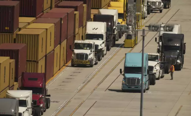 Truck await to load shipping containers at the Port of Los Angeles Wednesday, April 9, 2025, in Los Angeles. (AP Photo/Damian Dovarganes)
