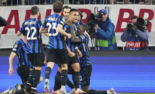 Inter Milan's Lautaro Martinez, center, celebrates with teammates after scoring opening goal during the Champions League quarterfinals first leg soccer match between FC Bayern Munich and Inter Milan, at the Allianz Arena in Munich, Germany, Tuesday, April 8, 2025. (AP Photo/Matthias Schrader)