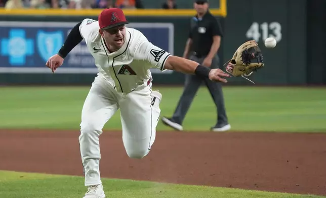 Arizona Diamondbacks second baseman Tim Tawa flips the ball towards first base on a ball hit by Milwaukee Brewers' Brice Turang in the seventh inning during a baseball game, Sunday, April 13, 2025, in Phoenix. (AP Photo/Rick Scuteri)
