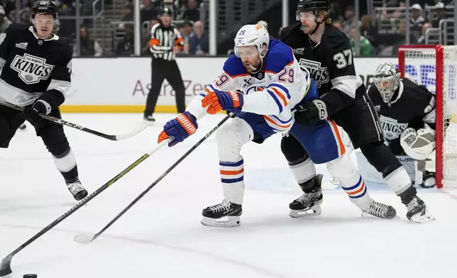 Edmonton Oilers center Leon Draisaitl (29) and Los Angeles Kings left wing Warren Foegele (37) go after the puck during the first period in Game 5 of an NHL hockey first-round playoff series Tuesday, April 29, 2025, in Los Angeles. (AP Photo/Mark J. Terrill)