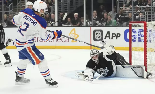 Los Angeles Kings goaltender Darcy Kuemper, right stops a shot by Edmonton Oilers defenseman Evan Bouchard during the first period in Game 5 of an NHL hockey first-round playoff series Tuesday, April 29, 2025, in Los Angeles. (AP Photo/Mark J. Terrill)
