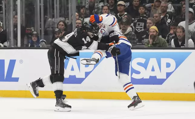 Los Angeles Kings right wing Alex Laferriere, left, puts a hit on Edmonton Oilers center Connor McDavid during the first period in Game 5 of an NHL hockey first-round playoff series Tuesday, April 29, 2025, in Los Angeles. (AP Photo/Mark J. Terrill)
