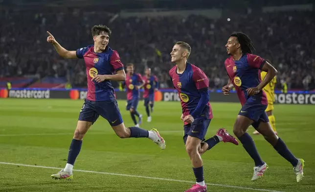 Barcelona's Pau Cubarsi, left, Barcelona's Fermin Lopez, center, and Barcelona's Jules Kounde celebrate after their teammate Raphinha, left, scores his side's opening goal during the Champions League quarterfinal first leg soccer match between Barcelona and Borussia Dortmund, at the Lluis Companys Olympic stadium in Barcelona, Spain, Wednesday, April 9, 2025. (AP Photo/Emilio Morenatti)