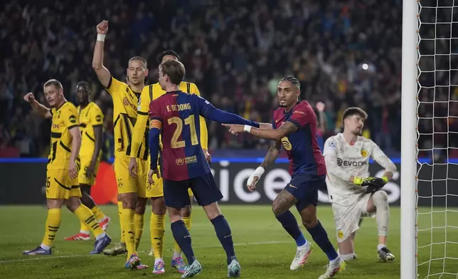 Barcelona's Raphinha, second right, celebrates after scoring his side's opening goal during the Champions League quarterfinal first leg soccer match between Barcelona and Borussia Dortmund, at the Lluis Companys Olympic stadium in Barcelona, Spain, Wednesday, April 9, 2025. (AP Photo/Emilio Morenatti)