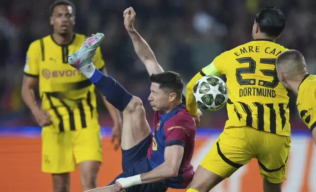 Barcelona's Robert Lewandowski, center, attempts a shot at goal in front of Dortmund's Emre Can during the Champions League quarterfinal first leg soccer match between Barcelona and Borussia Dortmund, at the Lluis Companys Olympic stadium in Barcelona, Spain, Wednesday, April 9, 2025. (AP Photo/Emilio Morenatti)