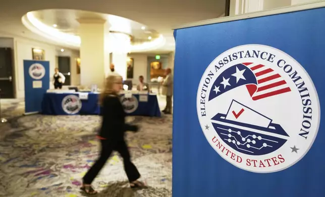 A meeting goer arrives for a U.S. Election Assistance Commission Standards Board in-person public meeting, Thursday, April 24, 2025, in Charlotte, N.C. (AP Photo/Chris Carlson)