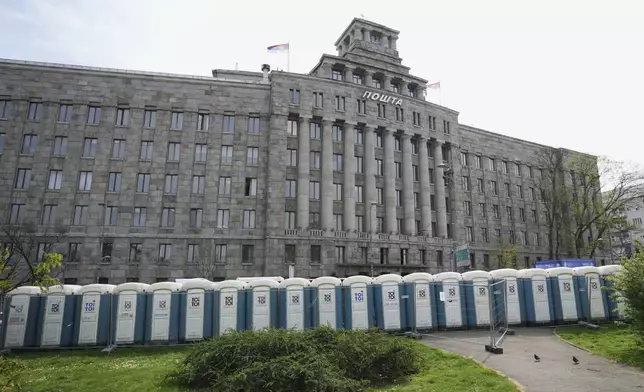 Temporary toilets are installed at street in front of main post office building ahead of a big counter-opposition protest rally planned to stage over the weekend in downtown Belgrade, Serbia, Friday, April 11, 2025. (AP Photo/Darko Vojinovic)