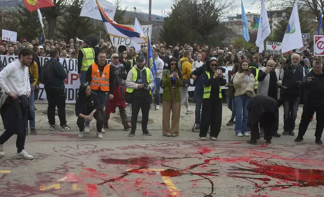 Protesters spill red paint in front of a local police station during an anti-corruption protest led by university students in the southwestern town of Novi Pazar, Serbia, Saturday, April 12, 2025. (AP Photo/Marko Drobnjakovic)