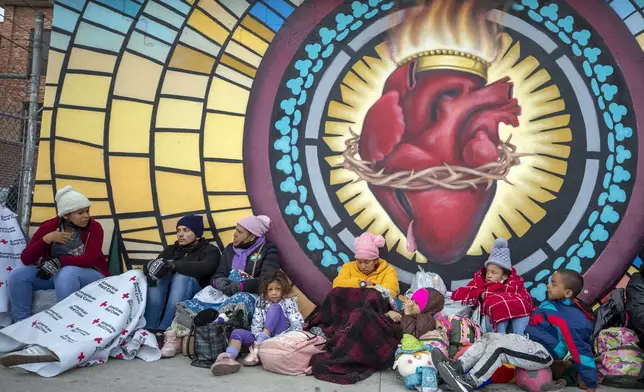 FILE - Migrants try to stay warm while camping outside the Sacred Heart Church in El Paso, Texas, on Sunday, Dec. 18, 2022. . (AP Photo/Andres Leighton, File)