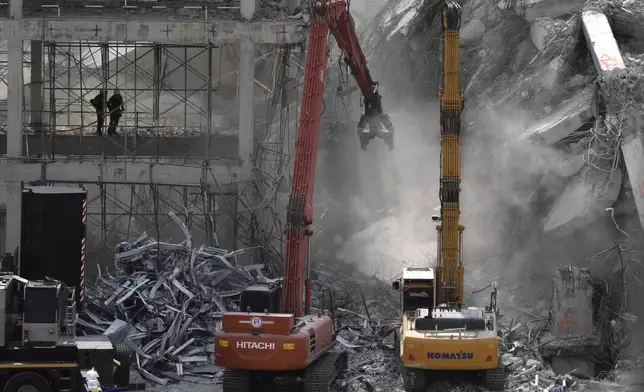 FILE - Soldiers from fire services spray water to settle the dust as heavy machineries are deployed to clear the rubble from an under construction high-rise building that collapsed after Friday's earthquake in Bangkok, Thailand, on April 2, 2025. (AP Photo/Manish Swarup, File)