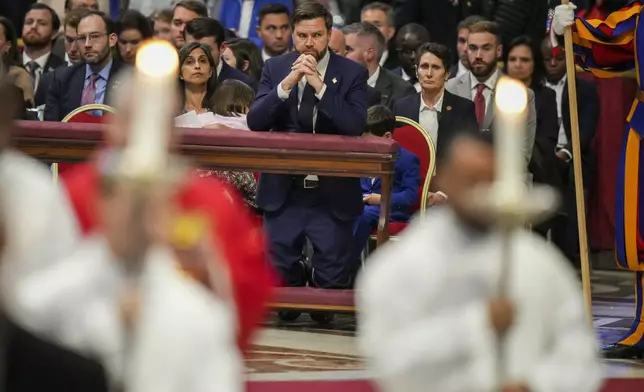 U.S. Vice President JD Vance attends with his wife Usha, left, a Good Friday service inside St. Peter's Basilica at the Vatican, Friday, April 18, 2025. (AP Photo/Alessandra Tarantino)