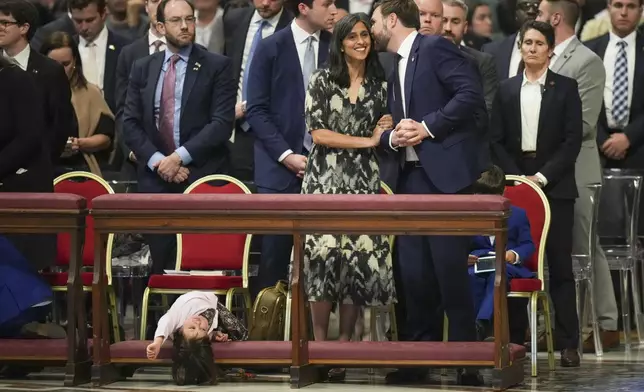 U.S. Vice President JD Vance, and his wife Usha Vance, center, with their daughter Mirabel attend a Good Friday service inside St. Peter's Basilica at the Vatican, Friday, April 18, 2025. (AP Photo/Alessandra Tarantino)