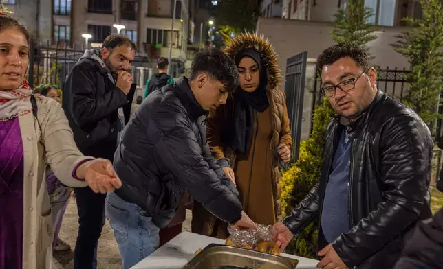 Locals collect food in a distribution point as they camp outdoors following an earthquake in Istanbul, Turkey, Wednesday, April 23, 2025. (Omer Yildiz/Dia Photo via AP)