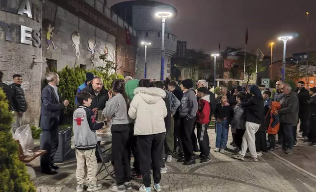 Locals collect food in a distribution point as they camp outdoors following an earthquake in Istanbul, Turkey, Wednesday, April 23, 2025. (Omer Yildiz/Dia Photo via AP)