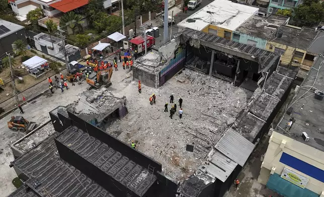 Rescue workers stand at the Jet Set nightclub days after its roof collapsed, killing more than 200 people in Santo Domingo, Dominican Republic, Thursday, April 10, 2025. (AP Photo/Matias Delacroix)