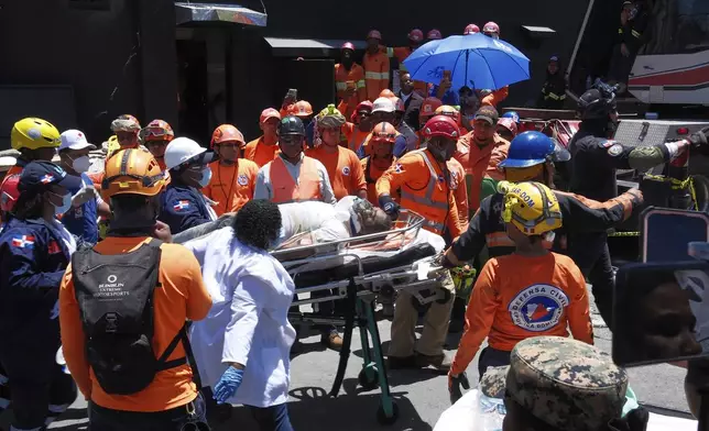 Rescue workers carry a person pulled from the wreckage of the Jet Set nightclub after its roof collapsed during a merengue concert in Santo Domingo, Dominican Republic, Tuesday, April 8, 2025. (AP Photo/Ricardo Hernandez)